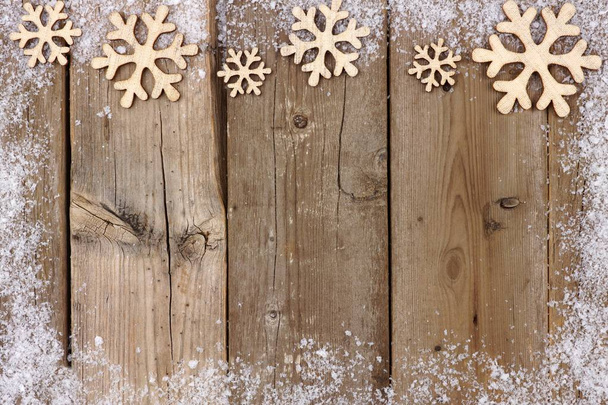 Christmas wooden snowflake top border with snow frame on wood - Photo, Image