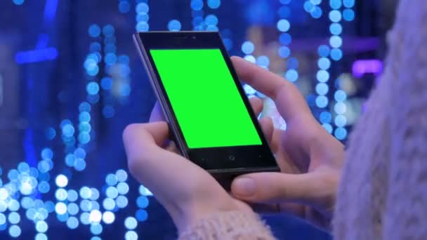 Nainen katselee älypuhelin vihreällä näytöllä - Materiaali, video