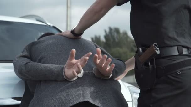 Policía arrestando a criminal en estacionamiento
 - Imágenes, Vídeo