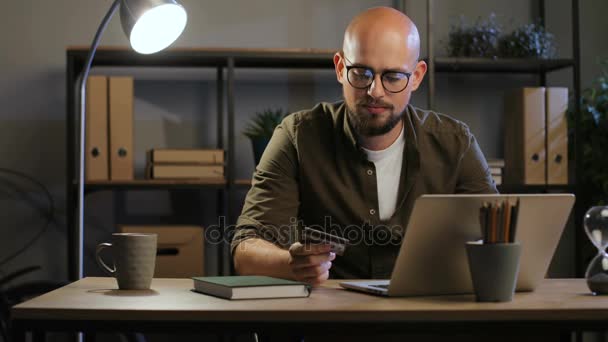 bald-headed man work with laptop - Кадры, видео