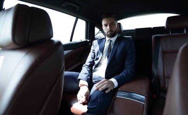 Successful businessman sitting in the back seat of a car - Фото, зображення