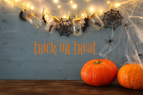 Halloween holiday concept. Masson jars with spiders, baths and wooden decorations - Foto, Bild