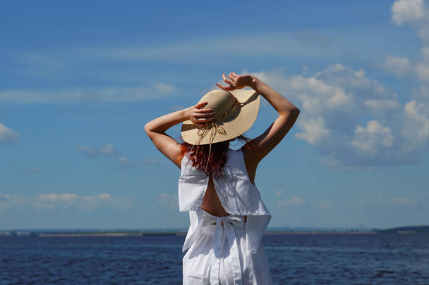 Cserzett nő fehér ruhában és kalapban a riverside - Fotó, kép