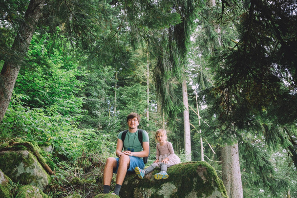 klein meisje en vader in bos  - Foto, afbeelding