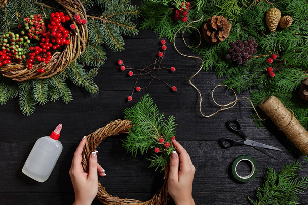 Κατασκευαστής του ντεκόρ Χριστουγέννων με τα χέρια τους. Χριστουγεννιάτικο στεφάνι για τις διακοπές. Εορτασμό του νέου έτους. Το Top view - Φωτογραφία, εικόνα