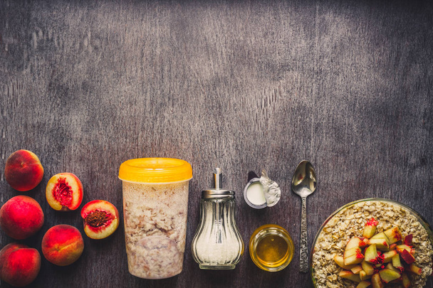 Ingredients for oatmeal on dark wooden table. Concept of healthy food. Top view, copy space. Toned - 写真・画像