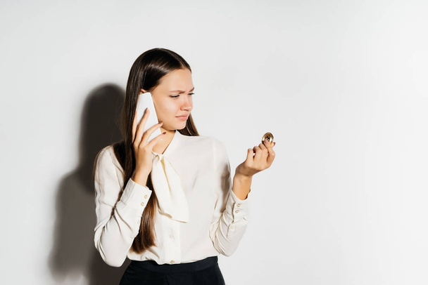 young business woman holding a golden bitcoin and talking on the phone - Foto, Imagem