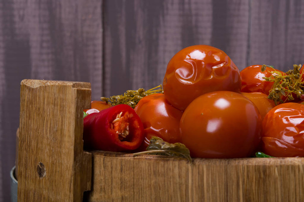 salted tomatoes in oak barrel, on a wooden background - Foto, Imagen