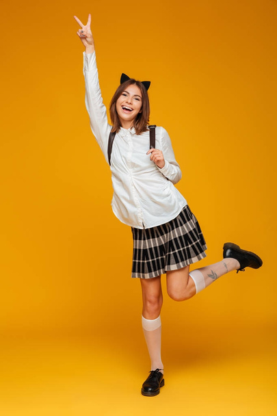 Full length portrait of a happy teenage schoolgirl - 写真・画像