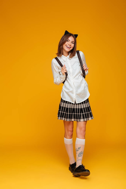 Full length portrait of a happy teenage schoolgirl in uniform - Фото, изображение
