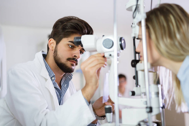 optometrist checking patient eyesight - Fotó, kép
