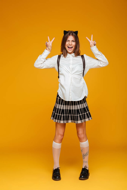 Full length portrait of an excited schoolgirl in uniform - Fotografie, Obrázek