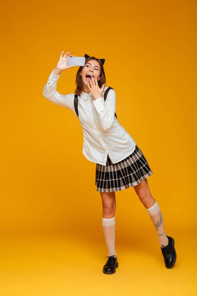 Full length portrait of a surprised happy teenage schoolgirl - Fotografie, Obrázek