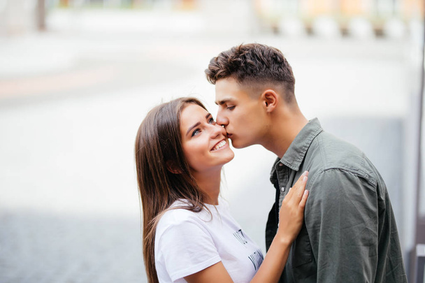 schöner junger Mann küsst seiner Geliebten auf der Straße die Wange - Foto, Bild