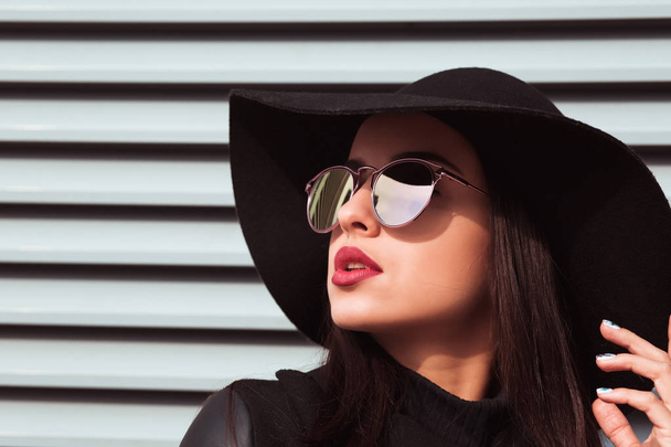 Closeup portret van jonge trendy model draagt hoed en sungla - Foto, afbeelding