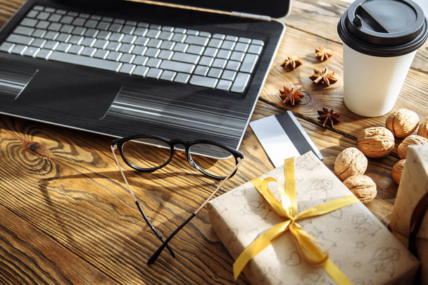 Shopping online with credit card for christmas holiday. Laptop with gifts on wooden table. - Foto, immagini
