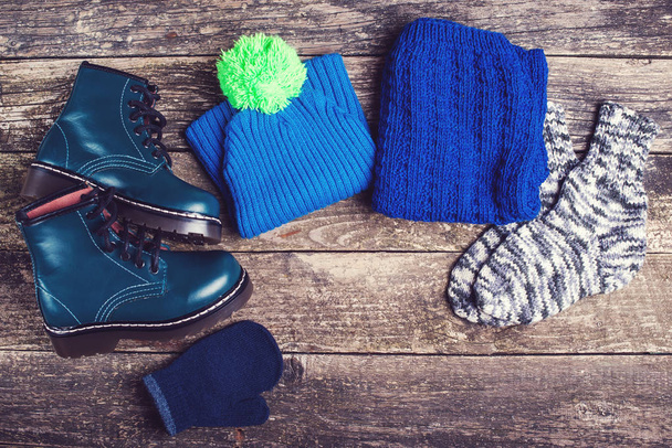 Autumn or winter outfit. Boy's fashion clothes and accessories on wooden background. - Photo, Image