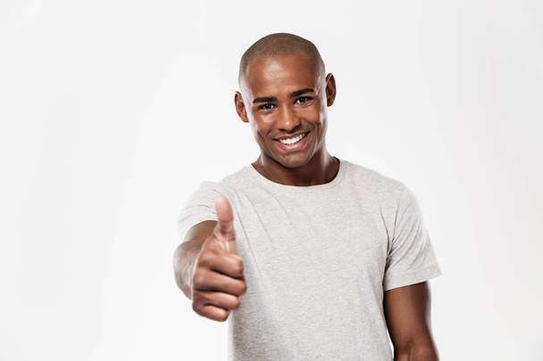 Cheerful young african man showing thumbs up. - Фото, зображення