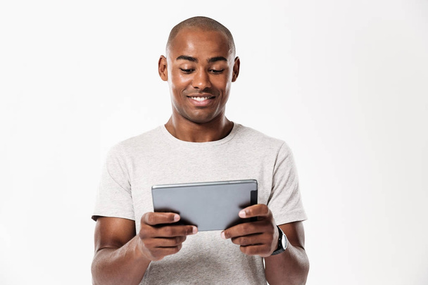 Smiling african man using tablet computer - Zdjęcie, obraz