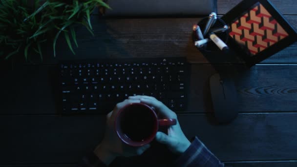 Pohled člověka pití kávy zatímco sedí v přední části počítače - Záběry, video