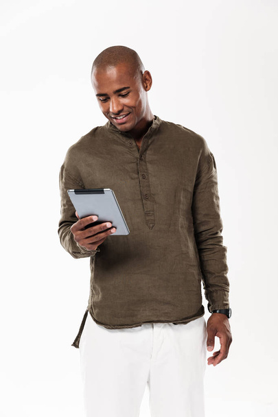 Immagine verticale di un uomo africano sorridente che usa un tablet
 - Foto, immagini