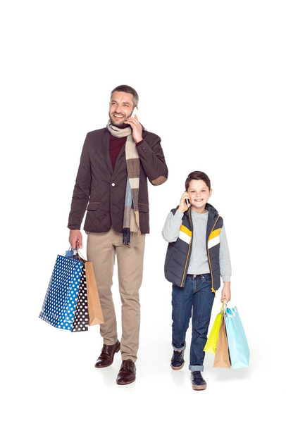 father and son with shopping bags and smartphones - Photo, Image