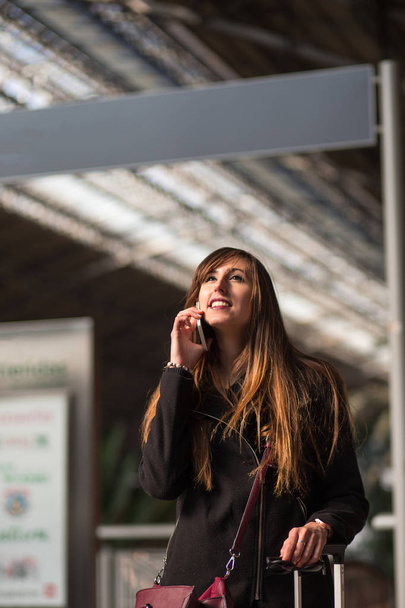 young woman talking on the phone in a station - Foto, Imagem
