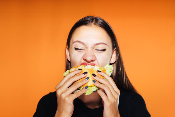 young girl wants to lose weight, but eats a harmful hamburger - Fotoğraf, Görsel
