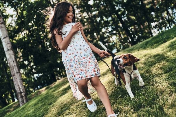 happy girl walking with beagle dog - Fotó, kép
