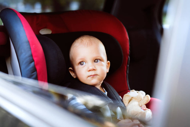Little baby boy sitting in the car seat in the car. - Zdjęcie, obraz