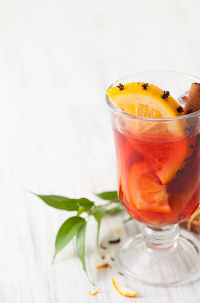 Part of a glass of mulled wine with slice of orange stuck with cloves - Foto, afbeelding