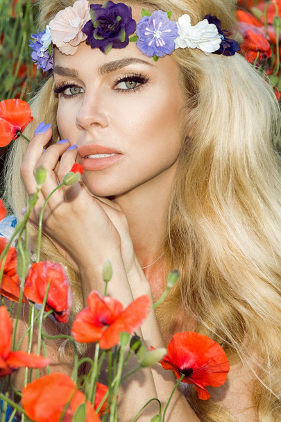 Kaunis blondi pitkät hiukset ja kauneus huulet, seisoo niitty punaisia unikkoja
 - Valokuva, kuva