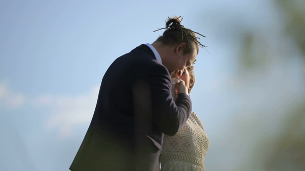 Newlywed couple holding hands Sight through the grass - Кадри, відео