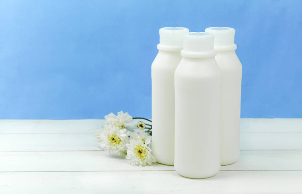 Una bottiglia di latte e un bicchiere di latte su un tavolo di legno su uno sfondo
 - Foto, immagini