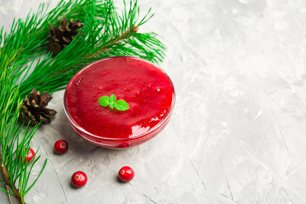 Red sauce or jam with christmas decoration over grey background - 写真・画像