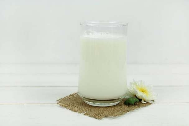 A bottle of milk and glass of milk on a wooden table on a  background - Photo, Image