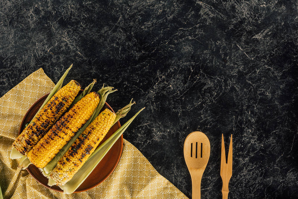 mazorcas de maíz a la parrilla con espátulas de madera
 - Foto, Imagen