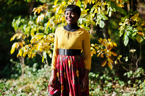 African american girl at yellow and red dress at autumn fall par - Foto, Imagen