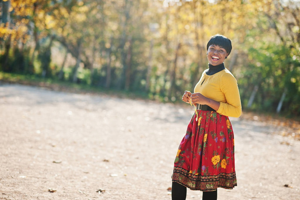 African american girl at yellow and red dress at golden autumn f - Foto, imagen