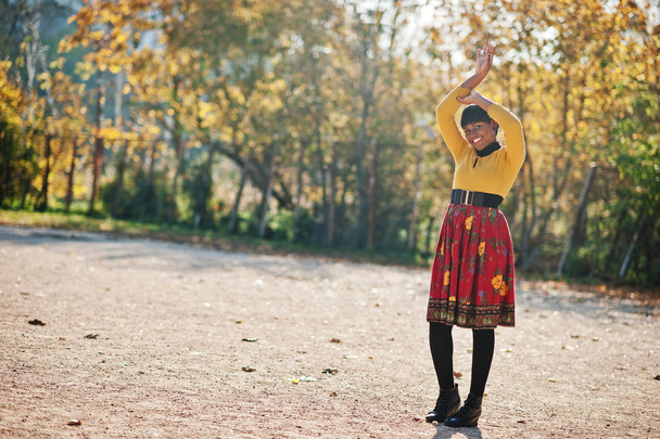African american girl at yellow and red dress at golden autumn f - Fotó, kép