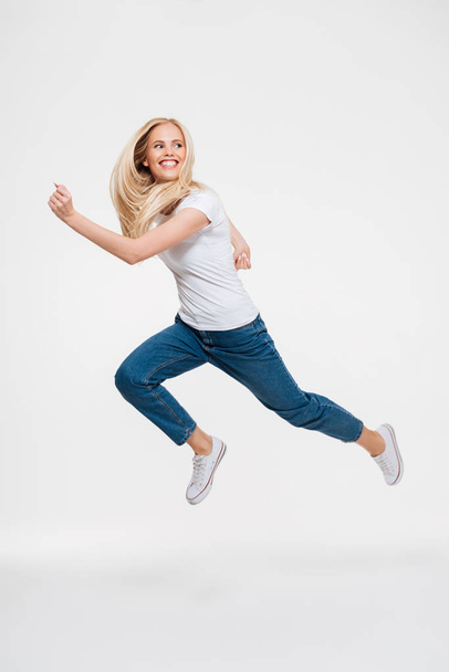 Full length portrait of a happy excited woman jumping - Foto, Bild