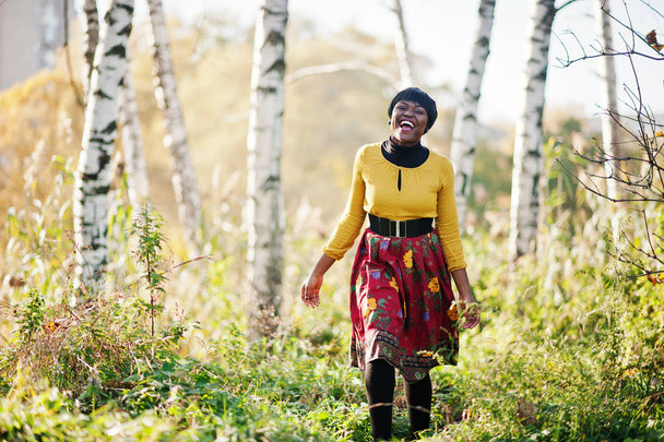 Αφρικανικό αμερικανικό κορίτσι στο κίτρινο και το κόκκινο φόρεμα στο χρυσή φθινόπωρο f - Φωτογραφία, εικόνα