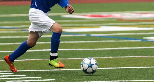 Γυμνάσιο ποδοσφαιριστής που τρέχουν με τη μπάλα - Φωτογραφία, εικόνα