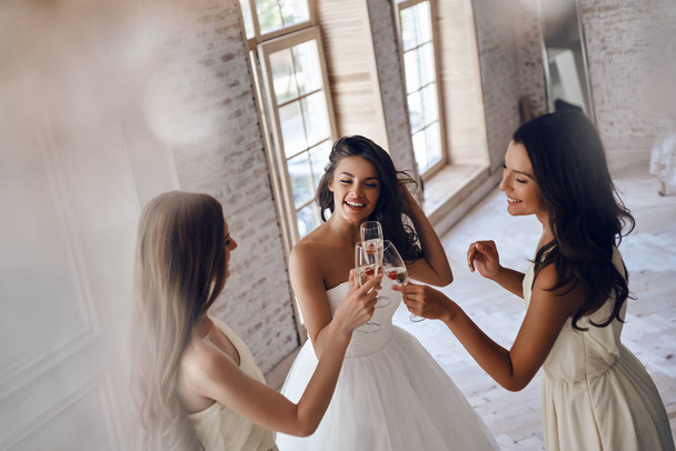 bride with beautiful bridesmaids drinking champagne - Photo, image
