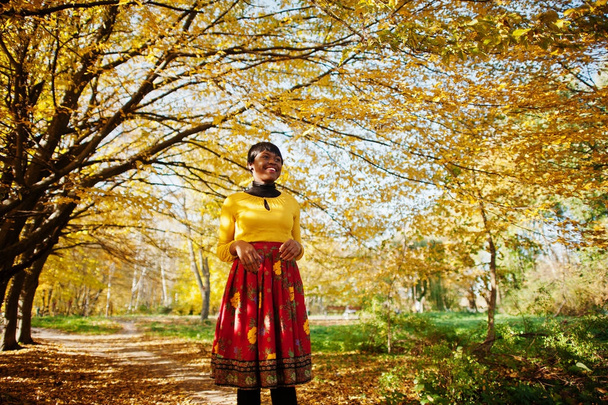 African american girl at yellow and red dress at golden autumn f - Foto, Bild