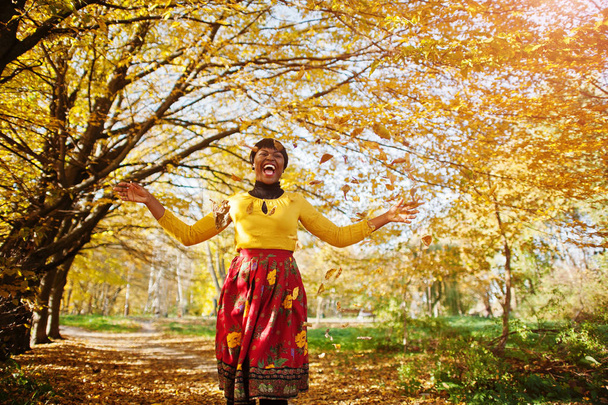 African american girl at yellow and red dress at golden autumn f - Zdjęcie, obraz