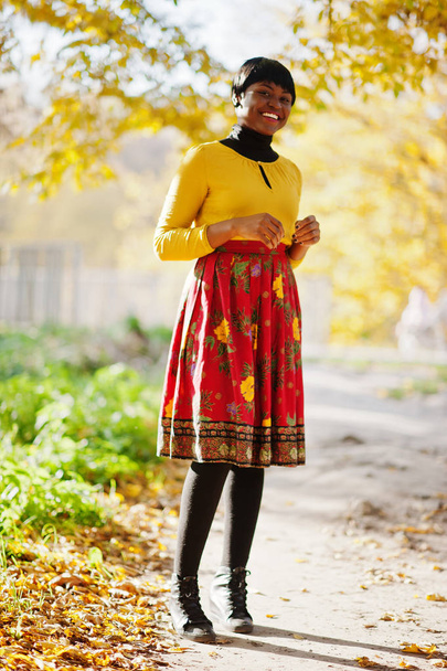 African american girl at yellow and red dress at golden autumn f - Valokuva, kuva