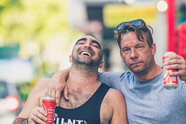 БАЛИ, ИНДОНЕЗИЯ - 12 ОКТЯБРЯ 2017: Два счастливых парня с пивом на улице Легиана, Кута, Бали
. - Фото, изображение