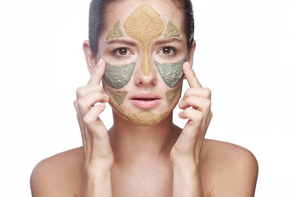 Portret van een meisje met een cosmetische masker op haar gezicht - Foto, afbeelding