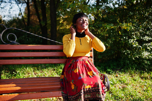 Chica afroamericana en vestido amarillo y rojo en otoño par
 - Foto, imagen
